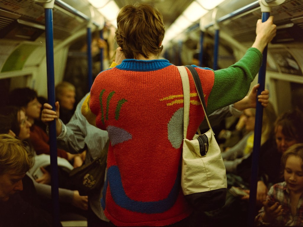 person in red jumper on the london underground