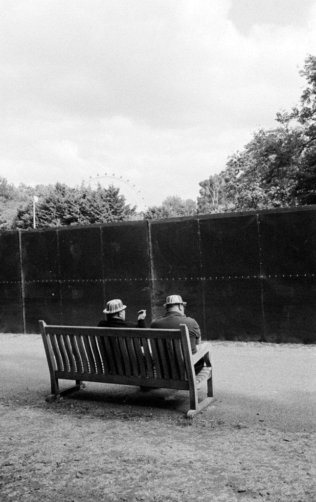 St James’s Park, London: Men with Union Jack hats on a bench with an obscured view