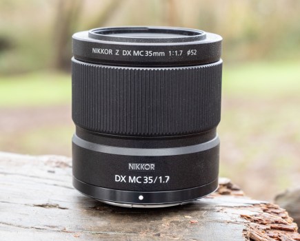 The Nikon Nikkor DX MC 35mm f/1.7 lens sitting on a log