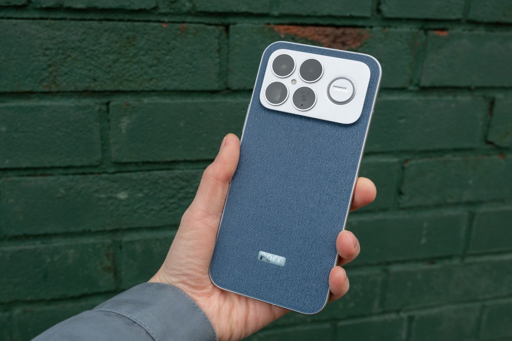 The Poco F8 Ultra in hand against a green wall