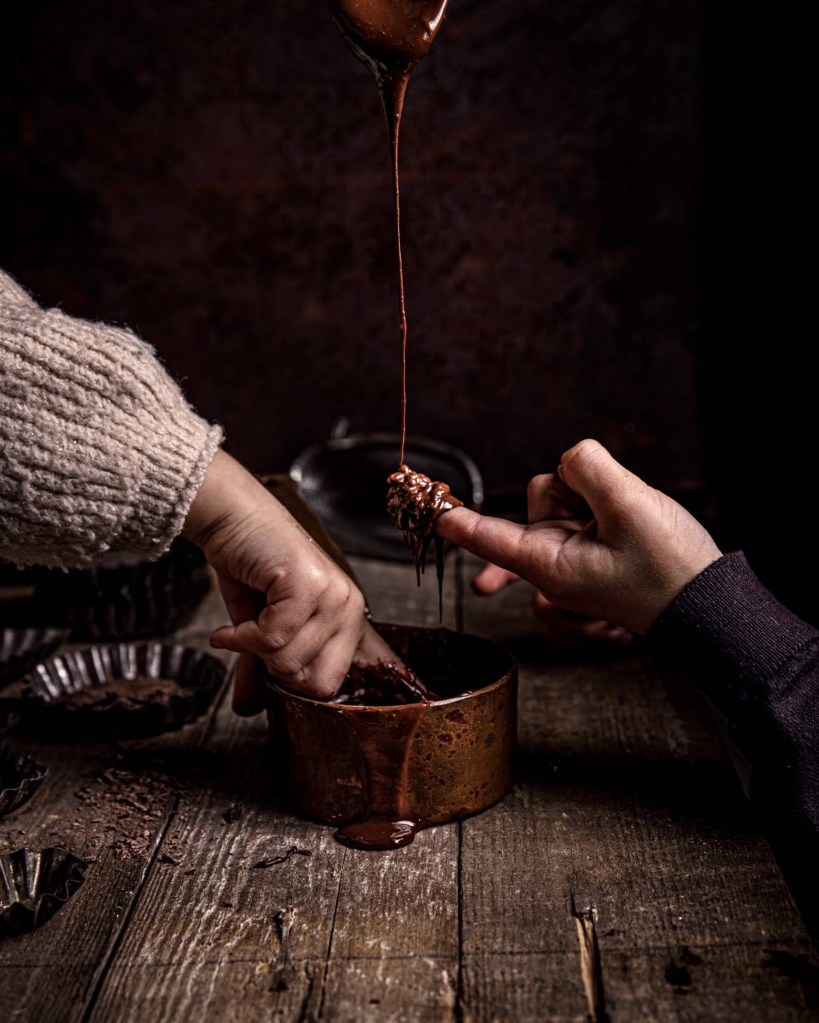drizzling chocolate on child's hands