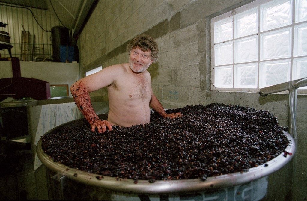 man stood in grapes mulching shirtless