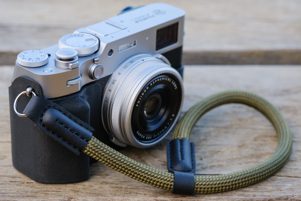 Akara Labs Slim Skin Case for the Fuijfilm X100VI, secured by a wriststrap. 