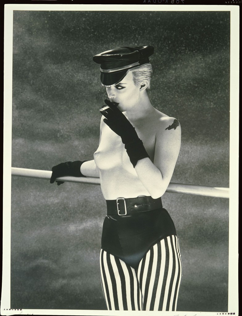 black and white photo of a topless woman smoking