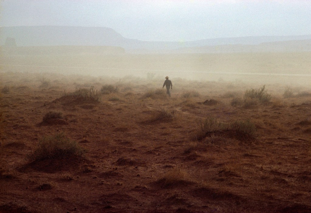 A Native American walks through the yellow landscape of a Nevada dust storm © Ernst Haas