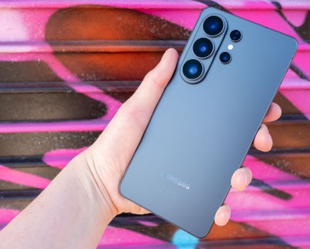 The Samsung Galaxy S26 Ultra in hand in front of a graffitied wall