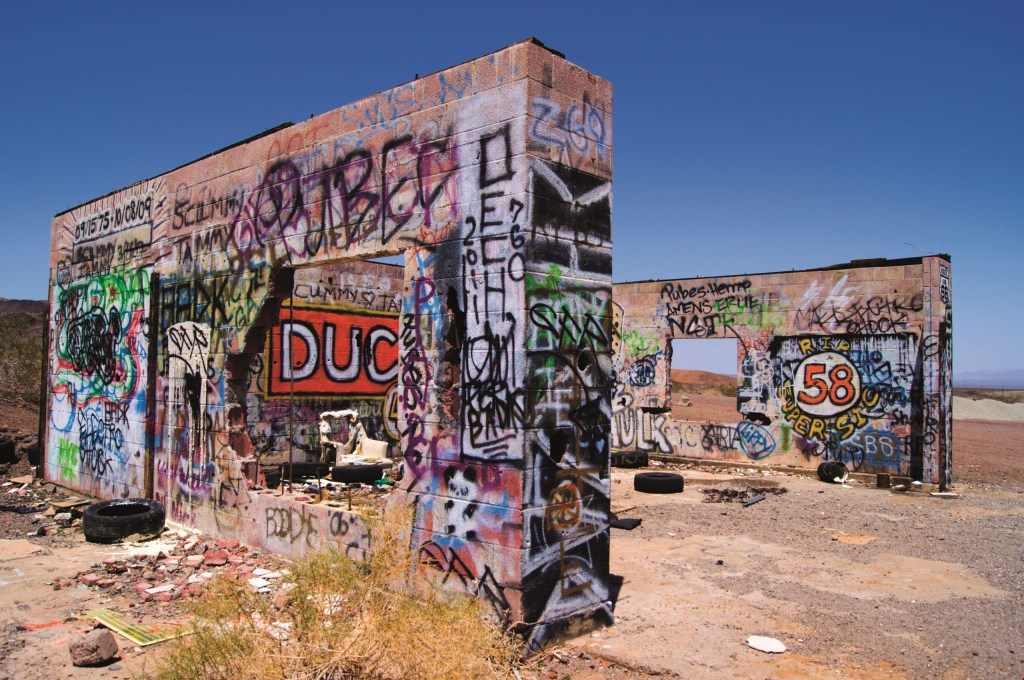A photo of the heavily graffitied ruins of a garage building at Cadiz Summit