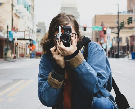 woman crouched on the street taking a photo