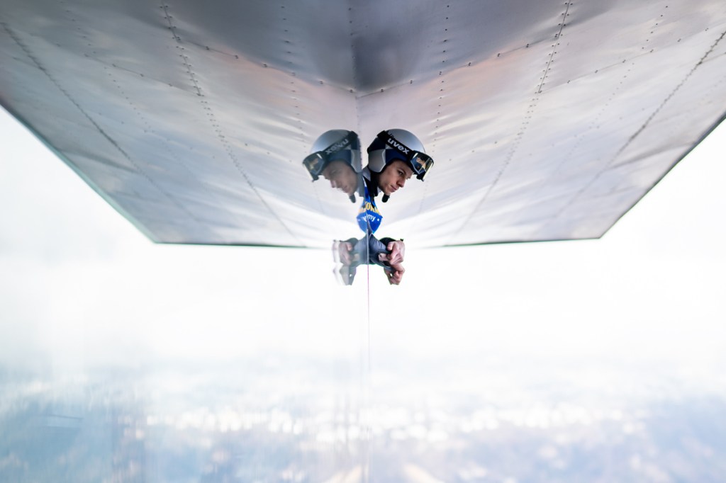 portrait of a skier looking out of building, symmetrical reflection