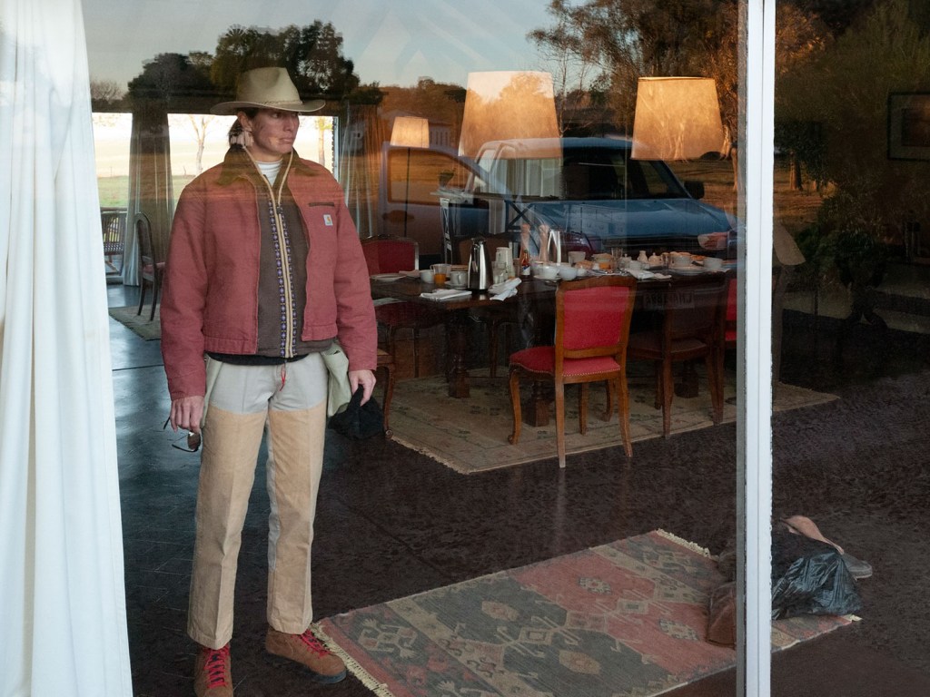 Photo of a window view  into a dining room with a man dressed in smart casual