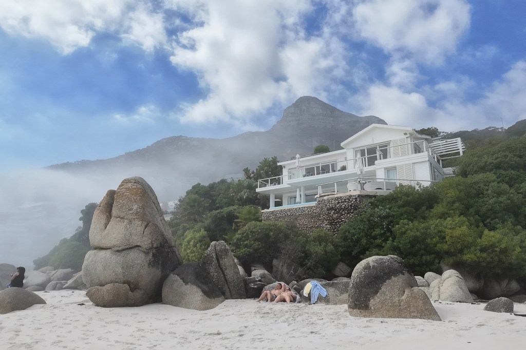 DJI Osmo Pocket 4 sample, two people on the beach with a house and mountain in the background