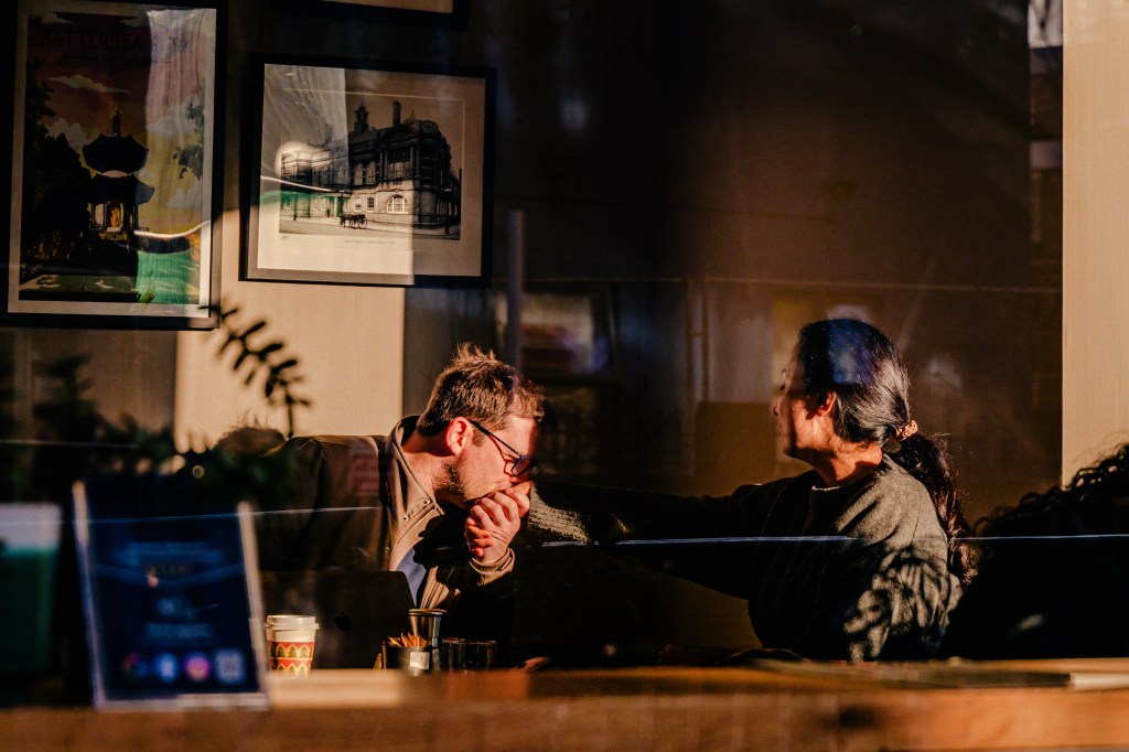 Nikon Nikkor Z 24-105mm f/4-7.1 lens sample, a man kissing a woman's hand in a cafe