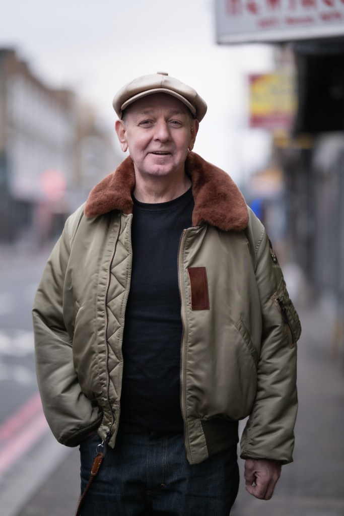 A portrait of a person wearing a flat cap