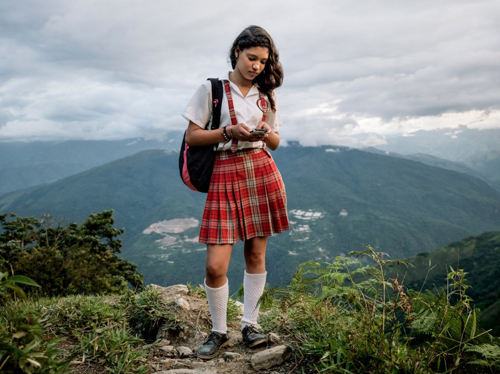 Twelve-year-old Alexandra Mazo walks down the mountain with her cellphone in hand after finishing her school day in Pueblo Nuevo, a village in Antioquia, Colombia, surrounded by vast coca plantations and armed groups, 2026. Image Credit: Mads Nissen