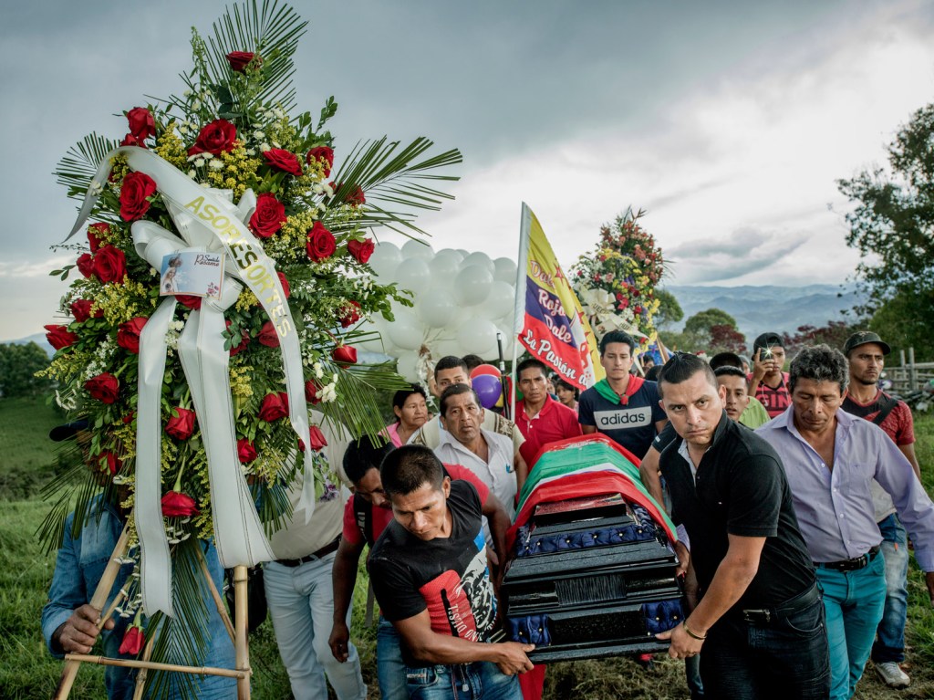 Surrounded by friends, family, and the entire community, Gerson Acosta is carried to his final resting place. At just 35-years-old, Acosta was already a governor and a respected Indigenous leader, known for his courage in standing up to armed groups attempting to take control of the Kite Kiwe ancestral territory. His defiance came at a high cost—he had received multiple death threats from a local paramilitary faction, a successor group of the far-right, drug-trafficking organisation AUC. On the afternoon of 19 April 2017, he was shot at close range outside his home. As the bullets were fired, Gerson managed to tell his 12-year-old son Daybi to run and escape. Timbío, Cauca, Colombia, 2026. Image Credit: Mads Nissen