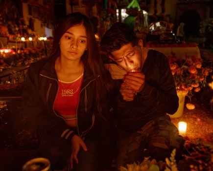 Twenty-three-year-old ‘Bélico’ and his girlfriend Yveth kneel before Santa Muerte, 2026. Image Credit: Mads Nissen