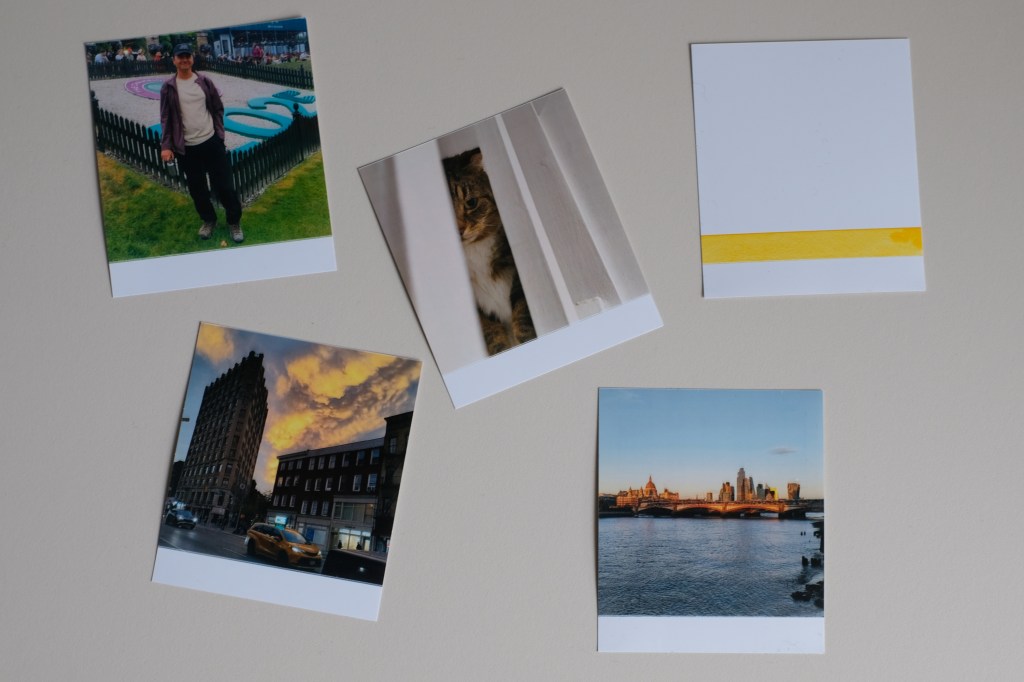 Photograph of Polaroid Hi-Print 3x3 printer photo examples, including a misprint