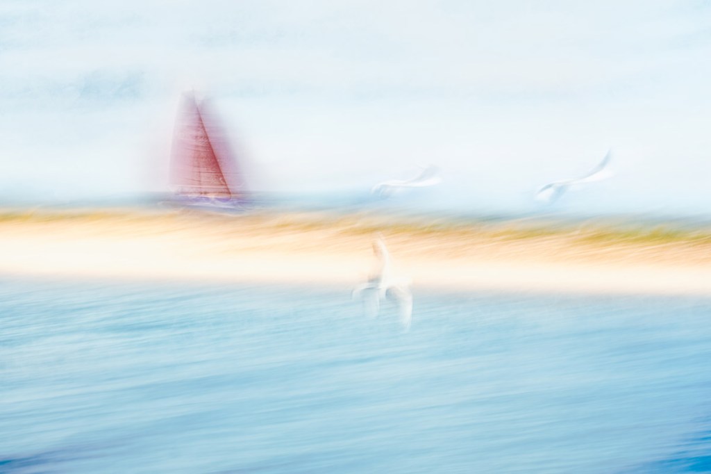 coastal scene blurred with red boat