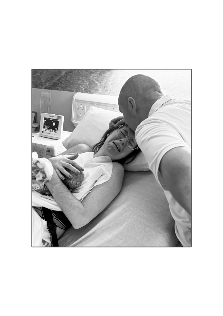 man kissing woman head after giving birth