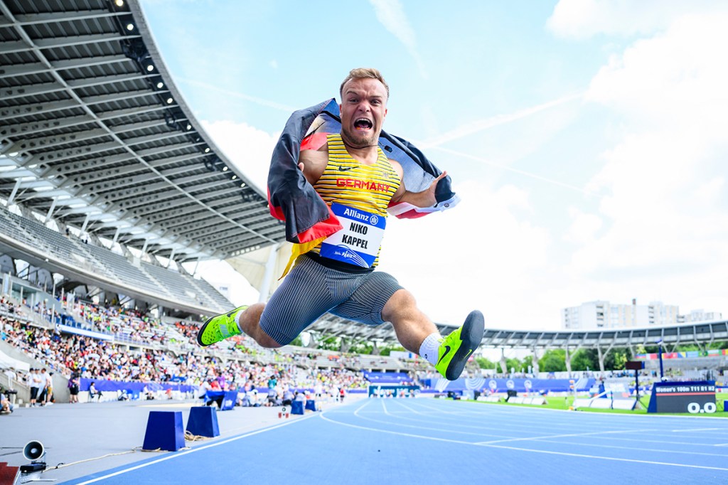Photo of German athlete Niko Kappel jumping with flag
