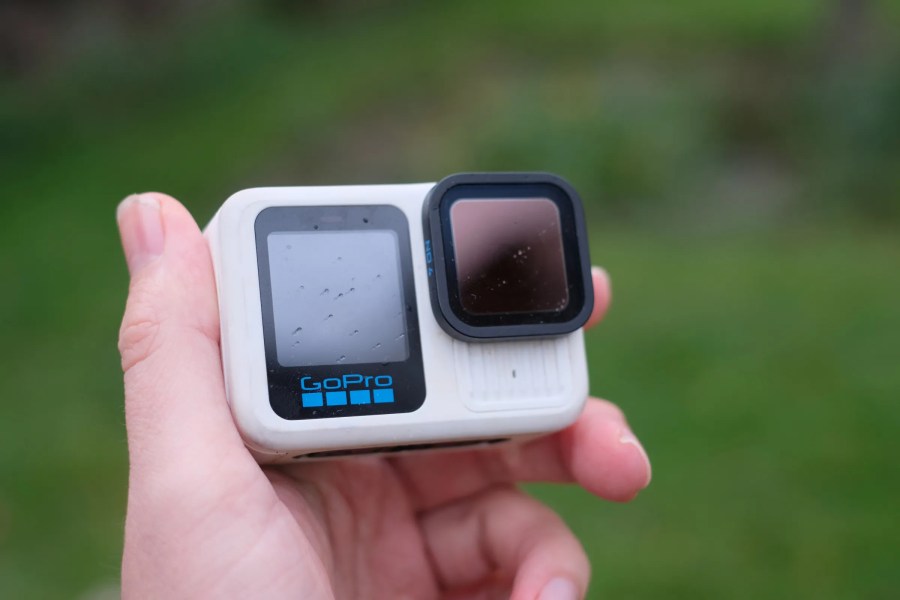 Man's hand holding GoPro Hero 13 Black in white colorway