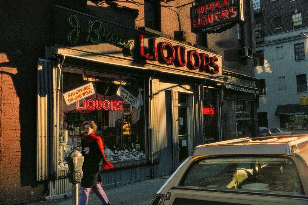 woman walking past a liquor store