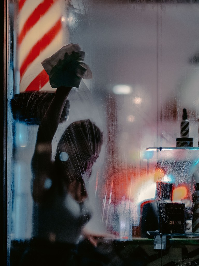 A colour image of a steamy windows through a hairdresser