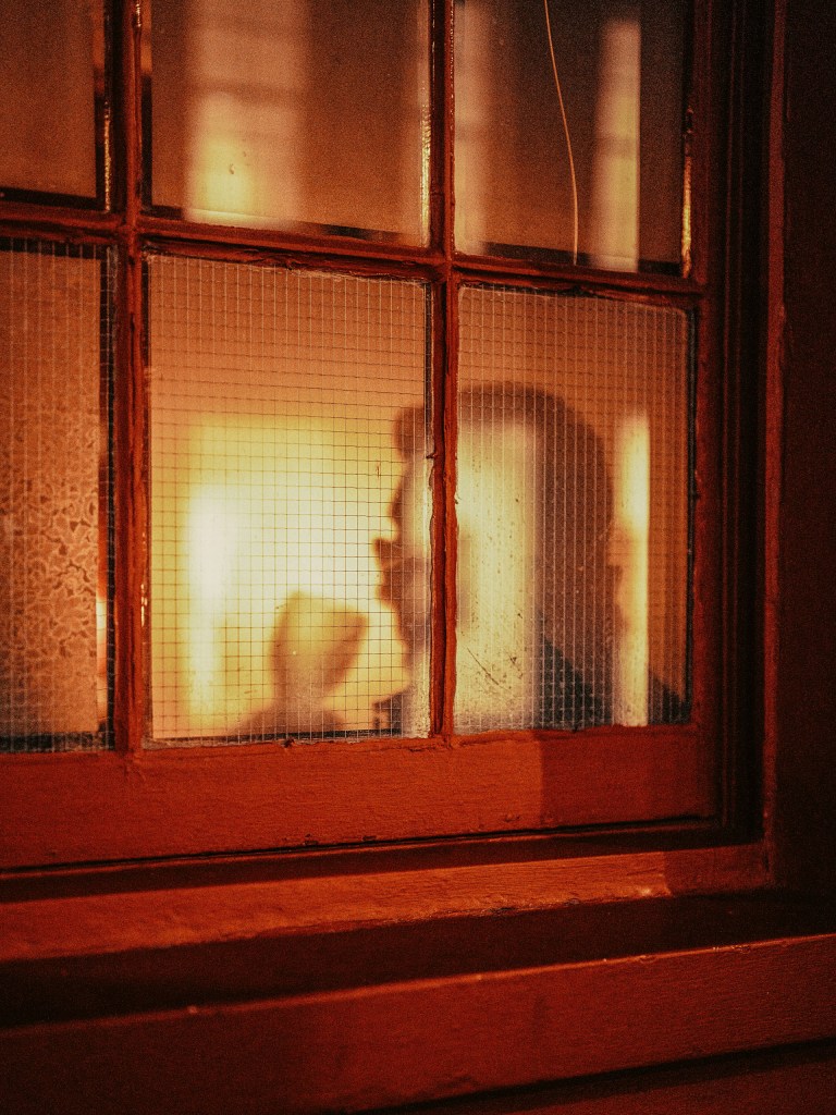 shadow of someone holding a wine glass