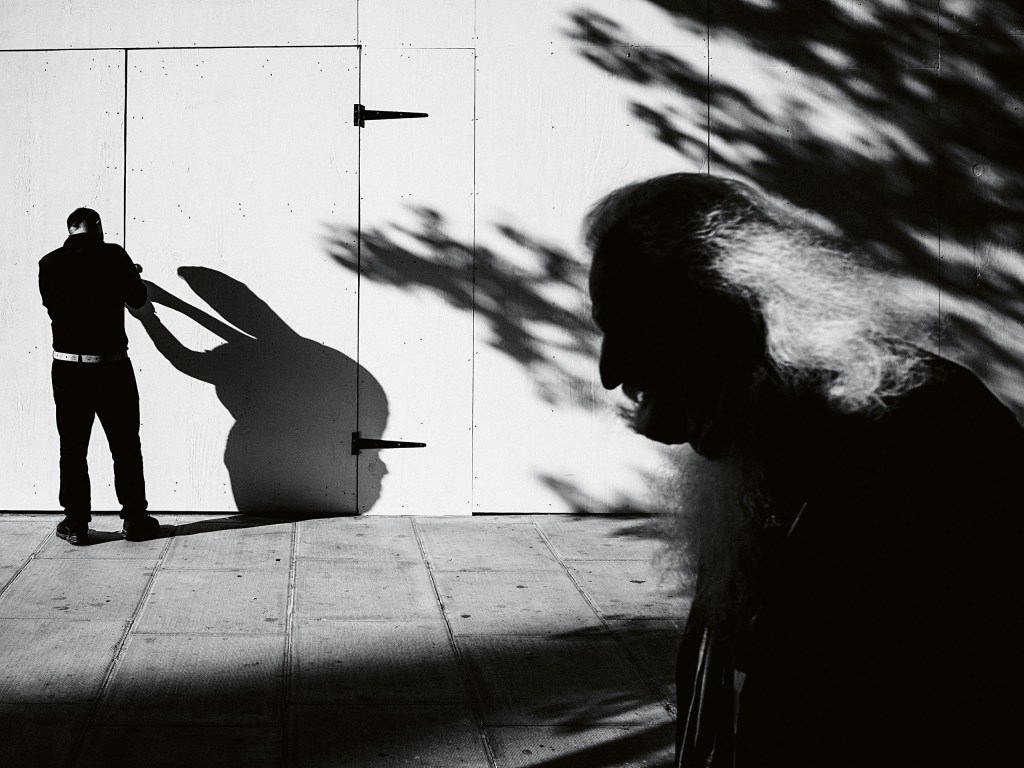 black and white photo of a man locking a door