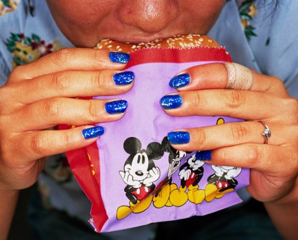 A close-up of a pair of hands holding a burger