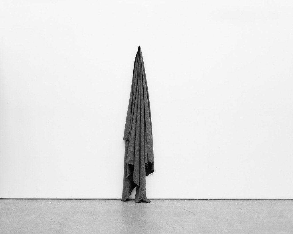 black and white photo of a cloth hanging on a wall