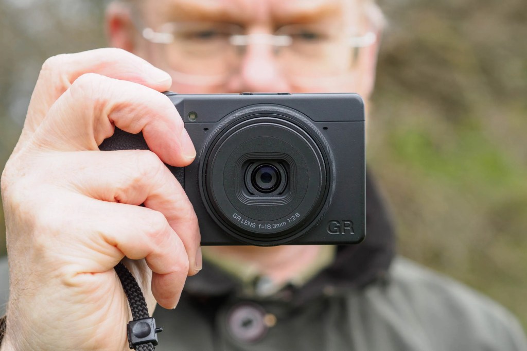 Man holding Ricoh GR IV Monochrome compact cameras