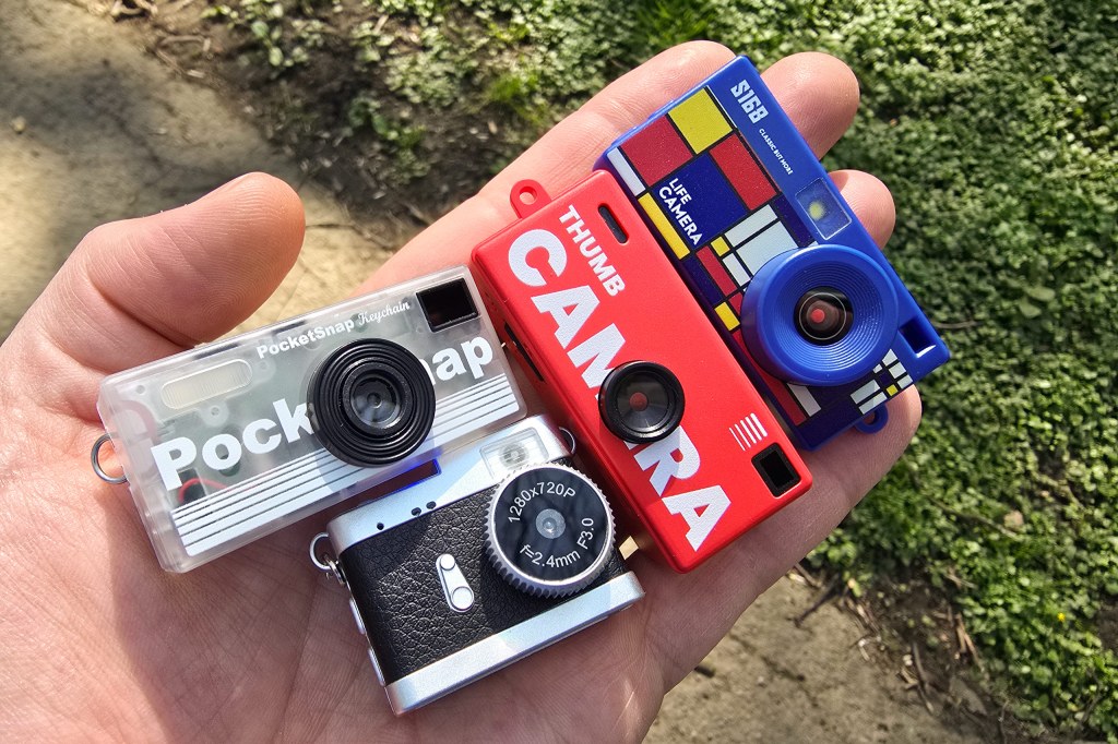 Thumb cameras: PocketSnap, Thumb Camera (G6: Red), Life Camera S168, and "Retro 720p" keychain camera. Image: JW