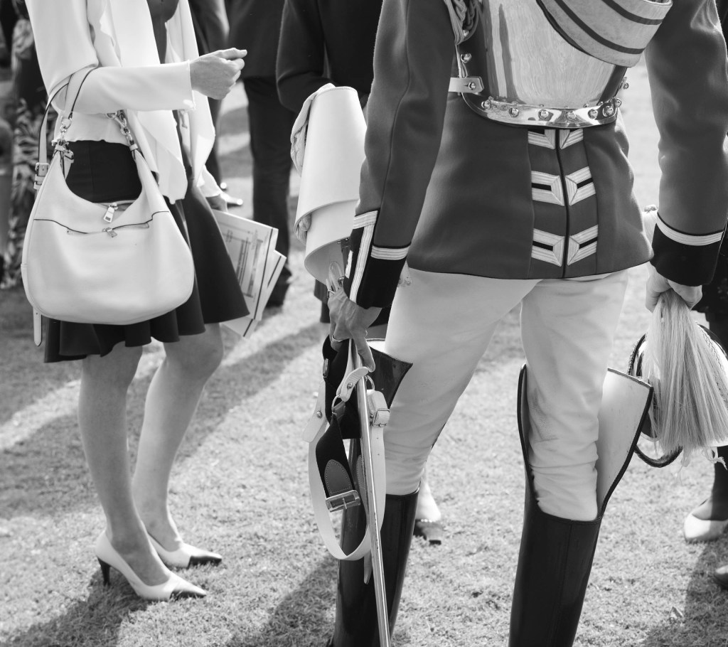 black and white photo of a person in military uniform standing next to someone in a skirt and heels