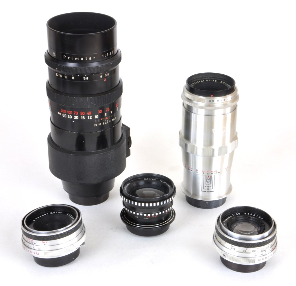 Just five of the many lenses made for the Praktina system: The Zeiss Flektagon 50mm f/2 standard, Zeiss Tessar 50mm f/2.8 standard, Enna Lithagon 35mm f/3.5 wide angle, Zeiss Triotar 135mm f/4 medium-tele, and Meyer-Optik Primotar 180mm f/3.5 telephoto.