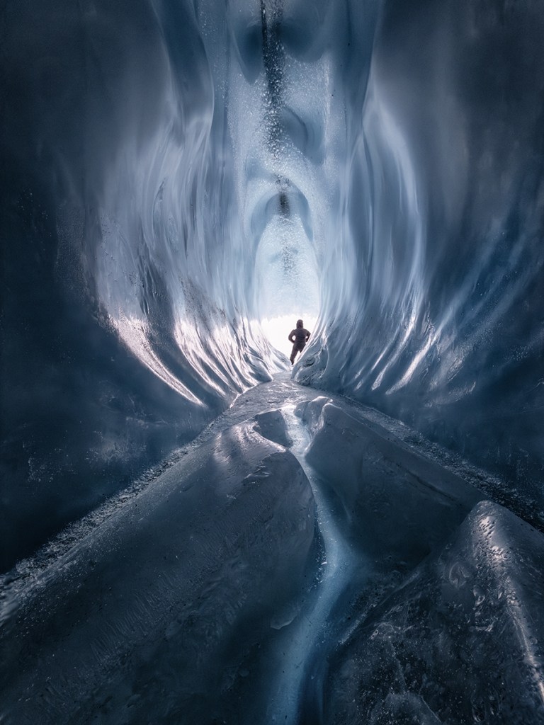 man stood inside ice cave