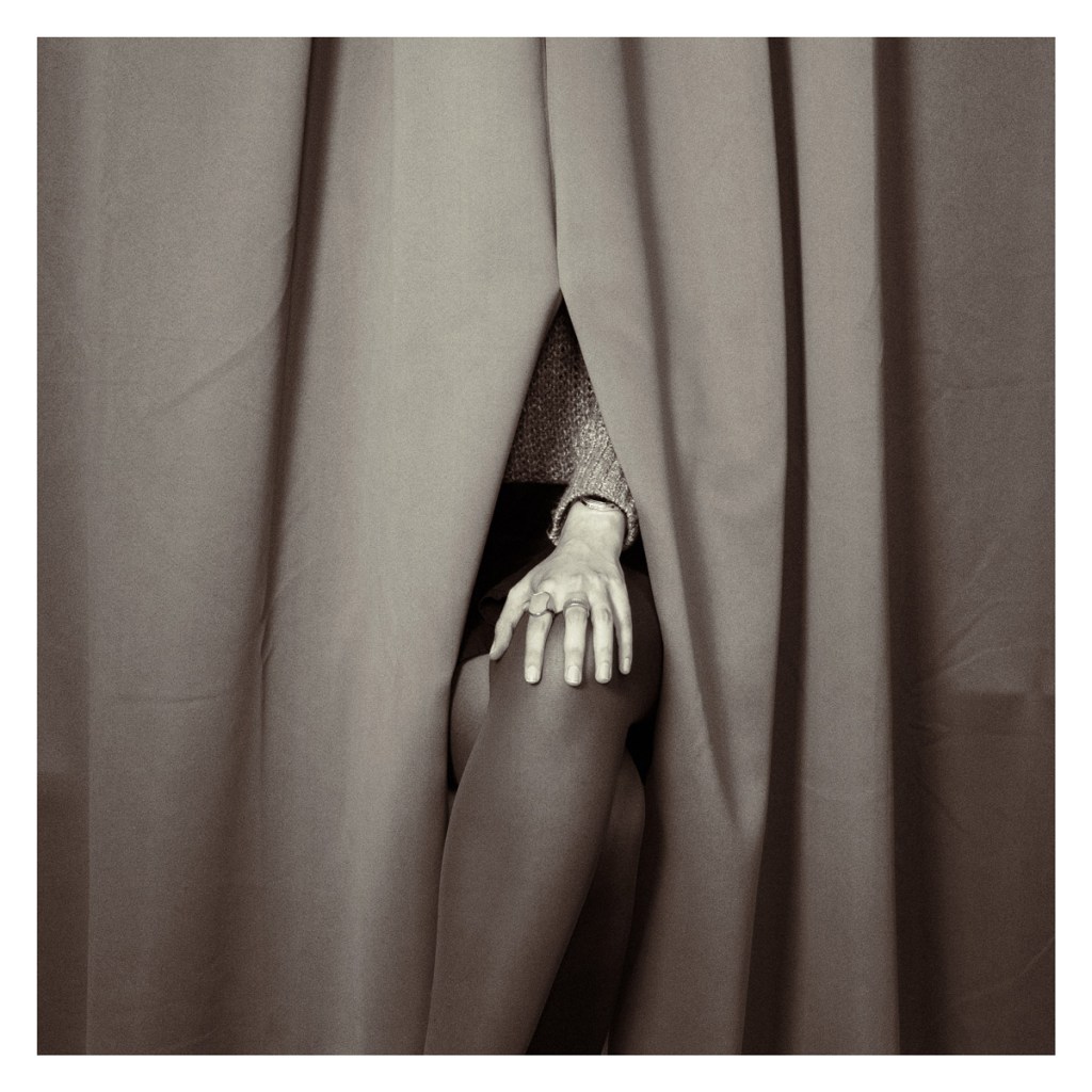 hand emerging from a curtain