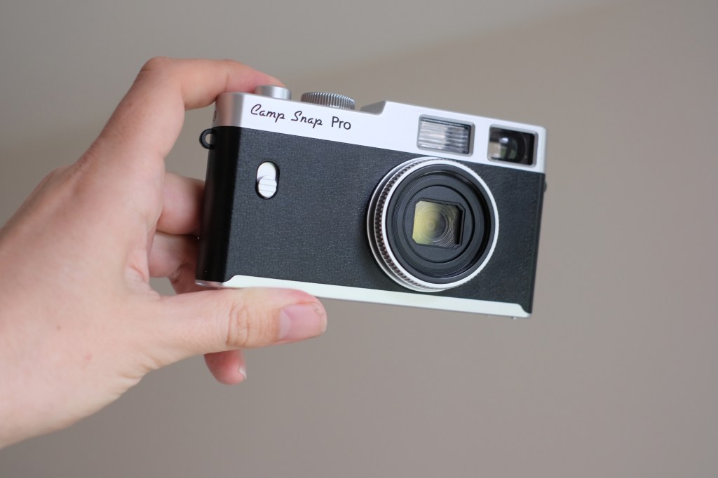 Photograph of the Camp Snap CS-PRO digital compact camera, held in one hand, lens facing