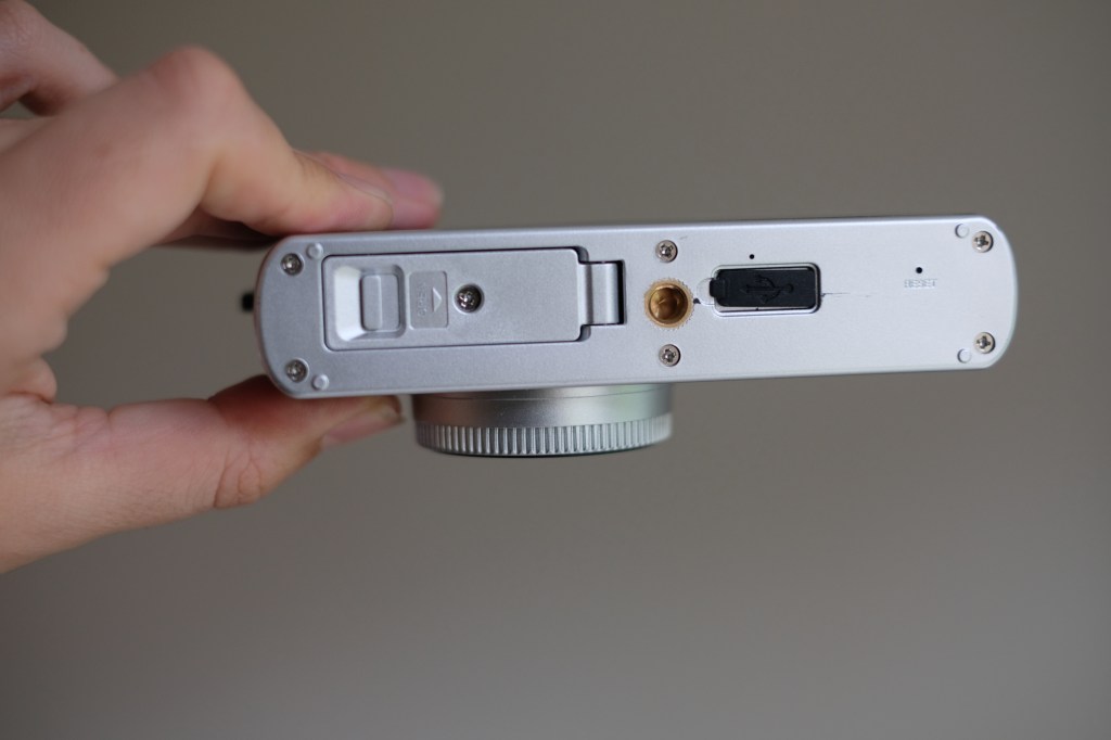 Photograph of the Camp Snap CS-PRO digital compact camera showing bottom plate with tripod thread and covered USB-C port and micro SD slot