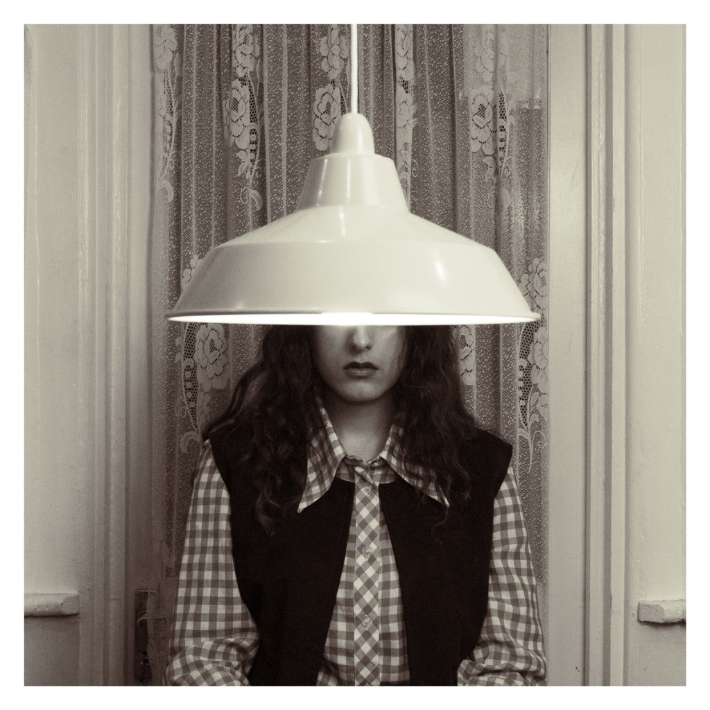 portrait of a woman sat behind a lampshade