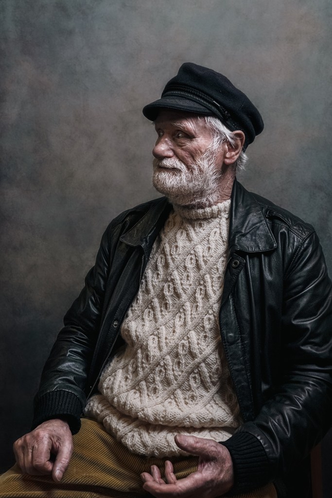 portrait of a man in a knit jumper and hat
