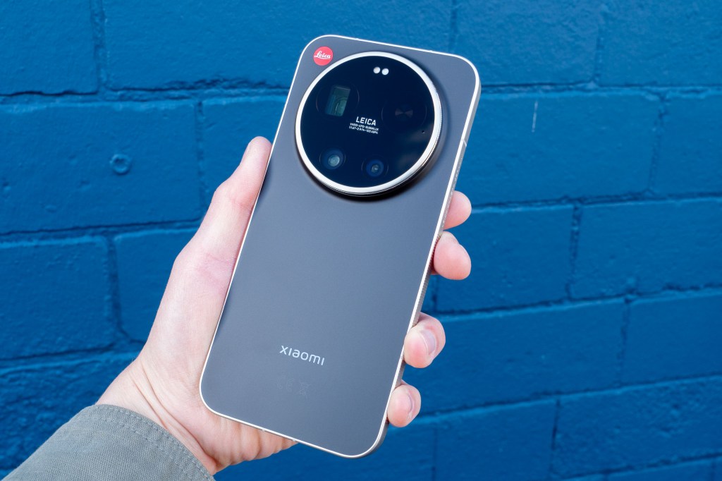 The Leica Leitzphone in hand against a blue brick wall