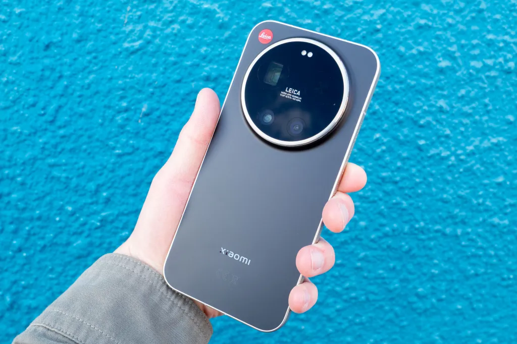 The Leica Leitzphone in hand against a blue wall