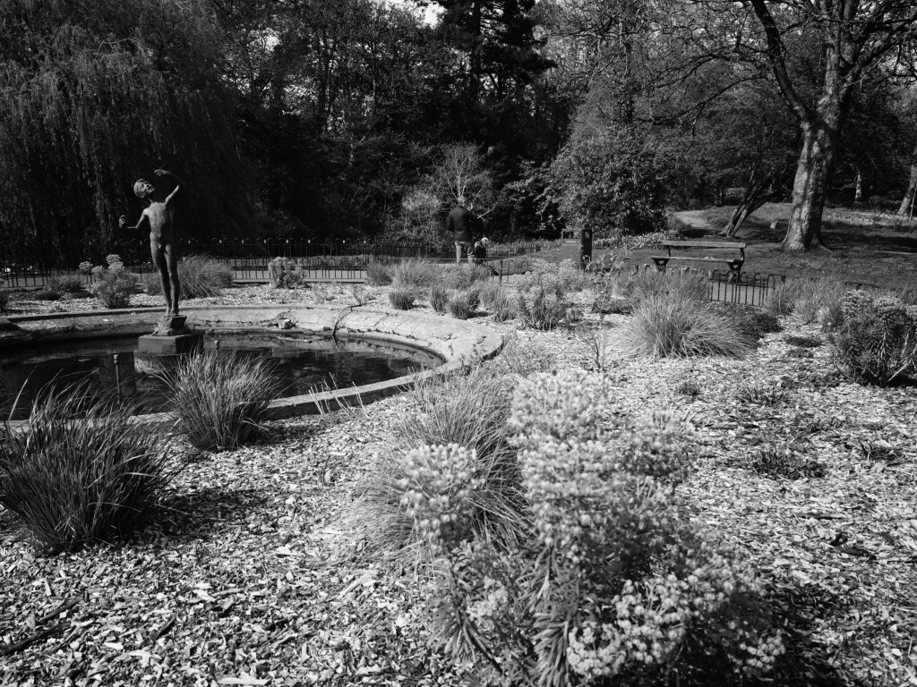 A statue in a park, the picture is monochrome