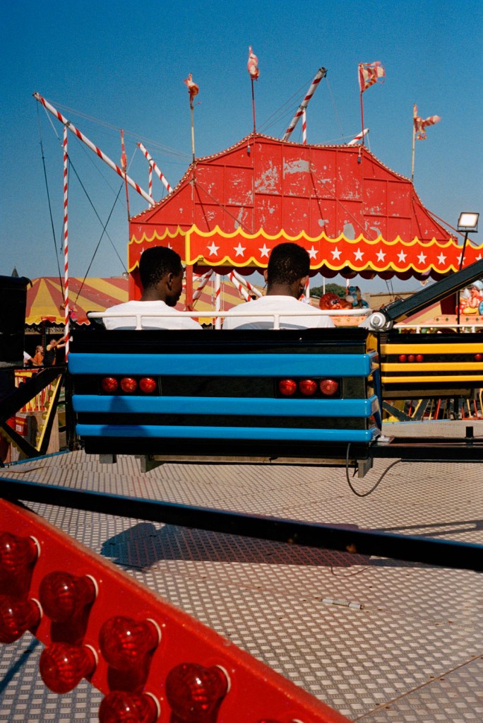 two people sitting on a ride at the beach