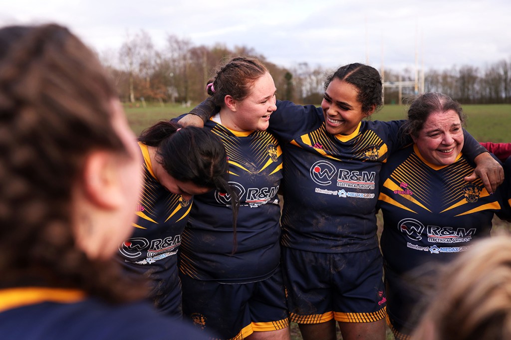 women stood in circle rugby team