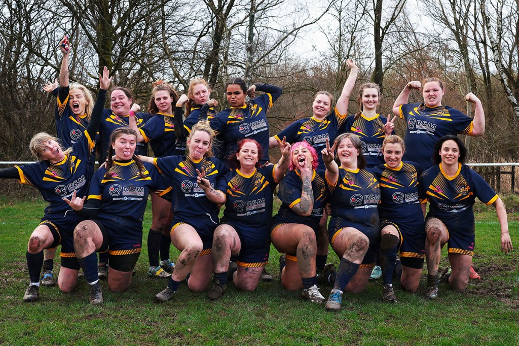 women rugby players pose for a group photo