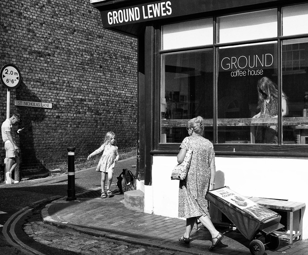 black and white photo of a girl running around the street corner