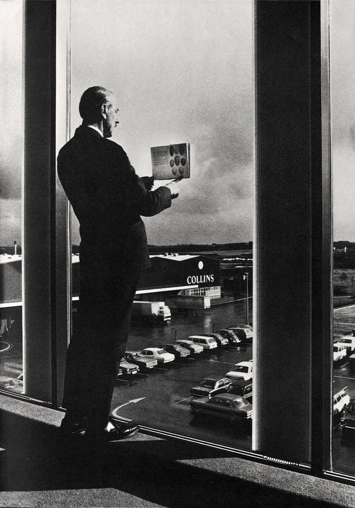 man in a suit holding a newspaper