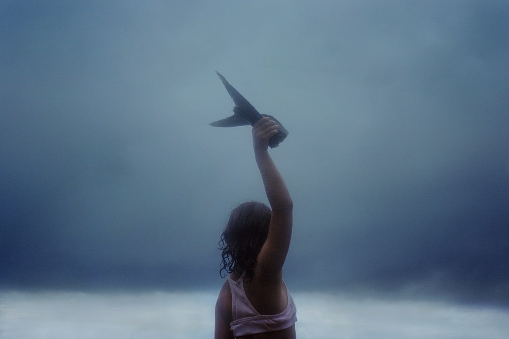 young girl holding up a fish tail